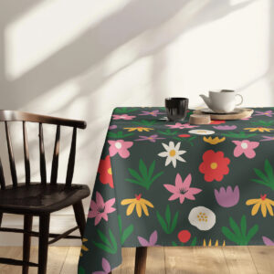 Widok rogu stołu z obrusem, wyraźne motywy tulipanów i stokrotek na tkaninie