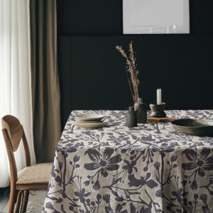 Aranżacja stołu z ustawionymi naczyniami i naturalnymi dekoracjami na obrusie w kwiaty