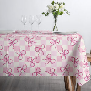 małe ujęcie z filiżanką i talerzykiem ustawionymi na obrusie z pudrową kratką i kokardkami