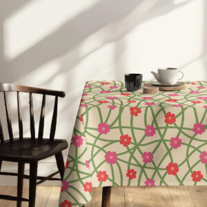 Stylizowane ujęcie stołu udekorowanego obrusm z drobnymi kwiatami i prostymi dodatkami