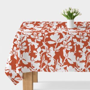 obrus z dużym białym wzorem kwiatowym na ceglastym tle, główne ujęcie stołu z białym wazonem