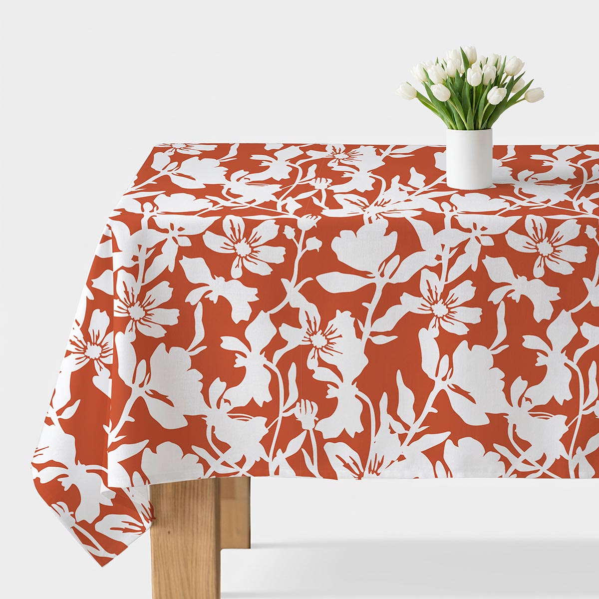 obrus z dużym białym wzorem kwiatowym na ceglastym tle, główne ujęcie stołu z białym wazonem