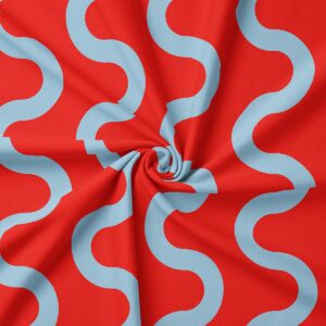 zbliżenie na tkaninę obrusu pokazujące błękitne faliste linie na czerwonym tle