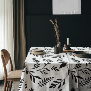 aranżacja stołu z czarno-białym obrusem, naczyniami i dekoracyjnymi dodatkami w stylu minimalistycznym