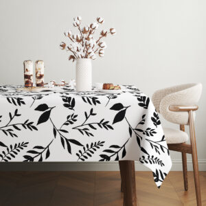 widok na róg stołu z rozłożonym obrusem i kontrastującym, graficznym wzorem liści