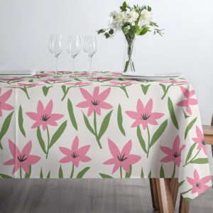 Szerokie ujęcie stołu udekorowanego obrusem z różowymi kwiatami oraz szkłem i białą porcelaną