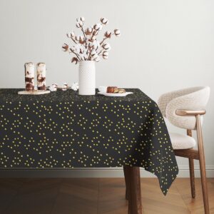 stylizowany stół z dekoracją i obrusem w delikatne złote kropki
