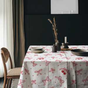 aranżacja stołu z ceramiczną zastawą, obrus w kokardki i wisienki w ciemnym wnętrzu