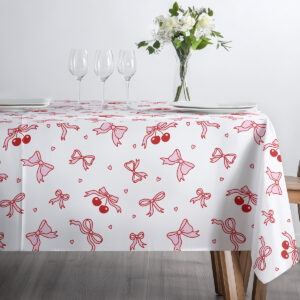 widok stołu z kieliszkami i talerzami, obrus z delikatnym, rysunkowym wzorem