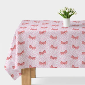 obrus z różowymi kokardkami na jasnym tle, widok główny na stole z wazonem białych tulipanów