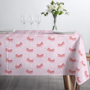 minimalistyczne ustawienie talerzy i kieliszków na obrusie z kokardkami