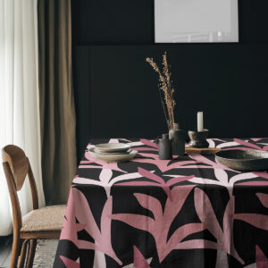 aranżacja stołu z obrusm na tle ciemnej ściany z naczyniami i naturalnymi dodatkami