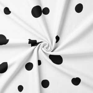 Zbliżenie na tkaninę obrusową z czarnymi, nieregularnymi kropkami i widocznym splotem