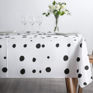 Widok z góry na obrus z czarnymi kropkami z ustawionymi talerzami i kieliszkami