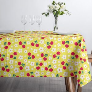 Stół nakryty obrusie z wiśniami i drobnymi białymi kwiatami