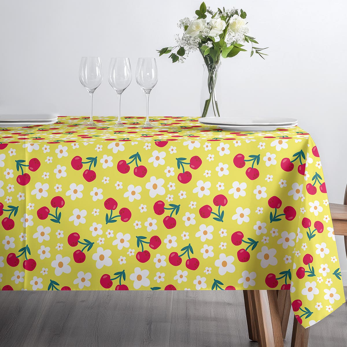 Stół nakryty obrusie z wiśniami i drobnymi białymi kwiatami