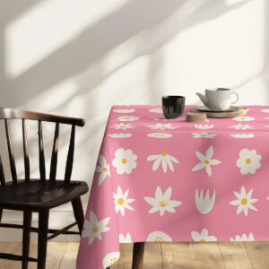 Poranna aranżacja z filiżanką i świecą na różowym obrusie z drobnymi białymi kwiatami