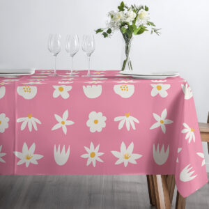 Widok stołu zastawionego szkłem i wazonem z kwiatami na różowym obrusie w stylizowane stokrotki