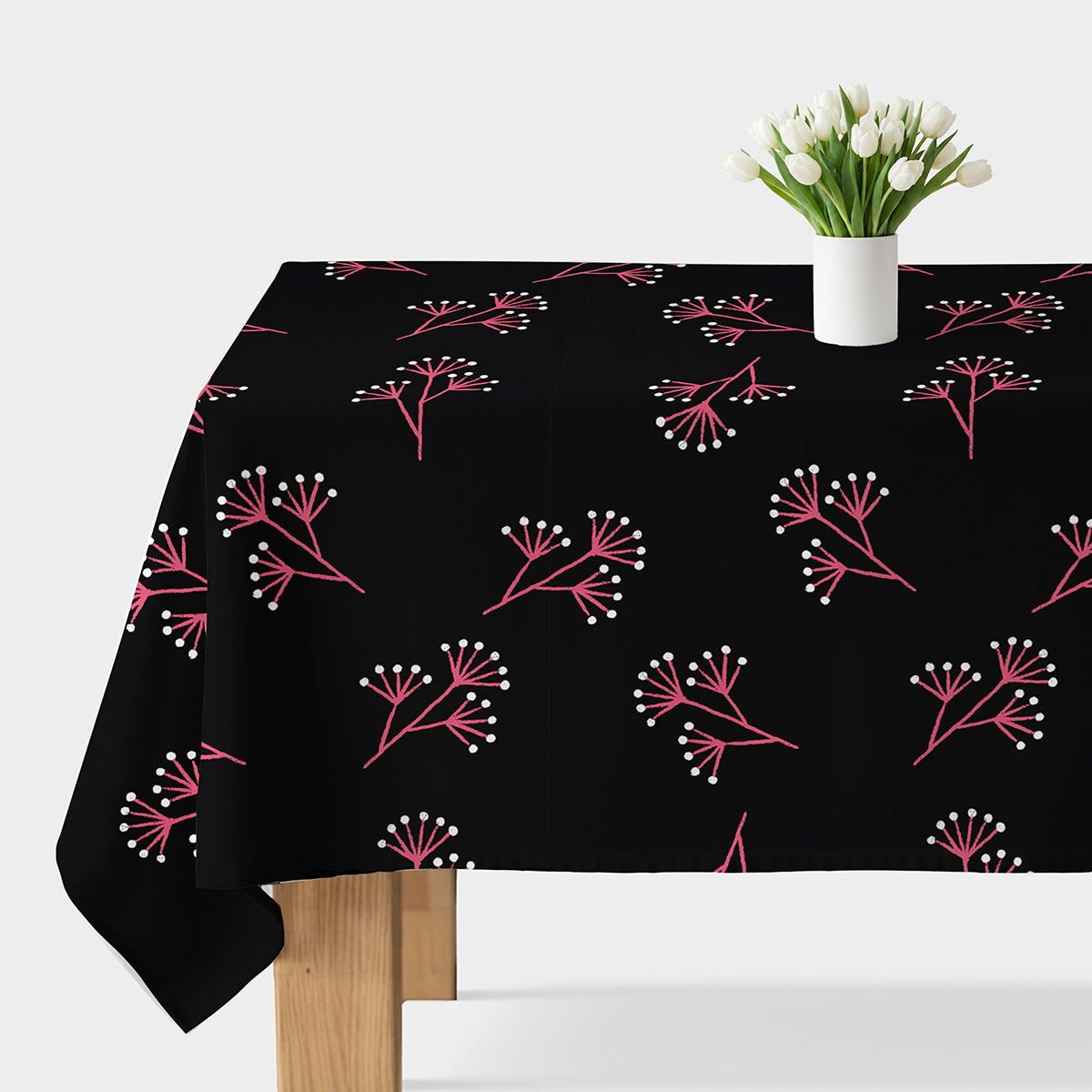 Czarny obrus na stole z wazonem białych tulipanów, widok główny na wzór różowych gałązek