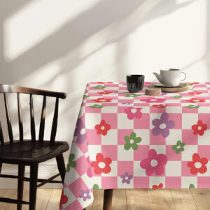 Widok stołu z krzesłem udekorowany obrusem w kratę i kwiaty