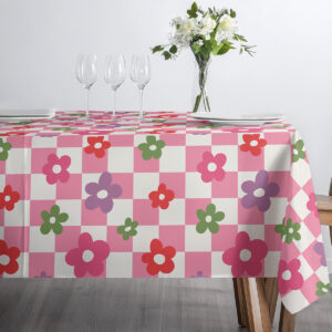 Górne ujęcie stołu z obrusem w różowe kratki i kwiaty z filiżanką i wazonem