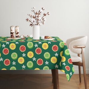 Widok stołu nakrytego obrusem z kolorowymi plasterkami oraz wazonem z kwiatami