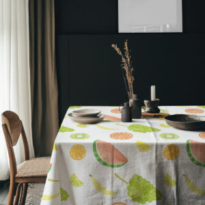 aranżacja stołu z naczyniami i świecami na obrusu z owocowym motywem