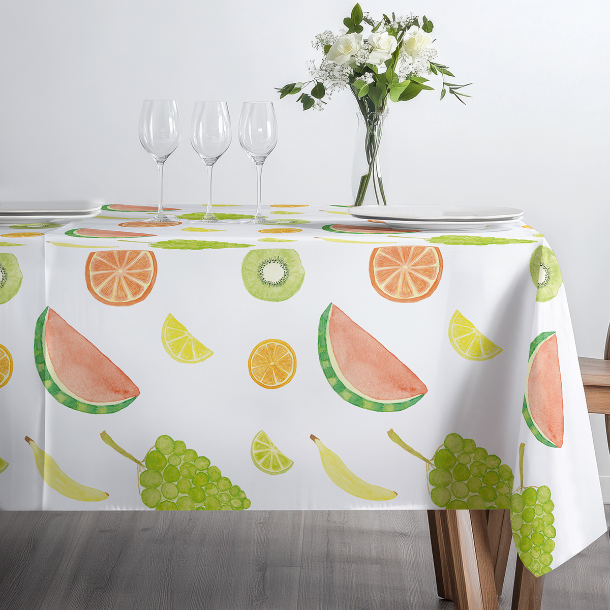 widok stołu z obrusem ozdobionym owocowym nadrukiem, kieliszki i zastawa