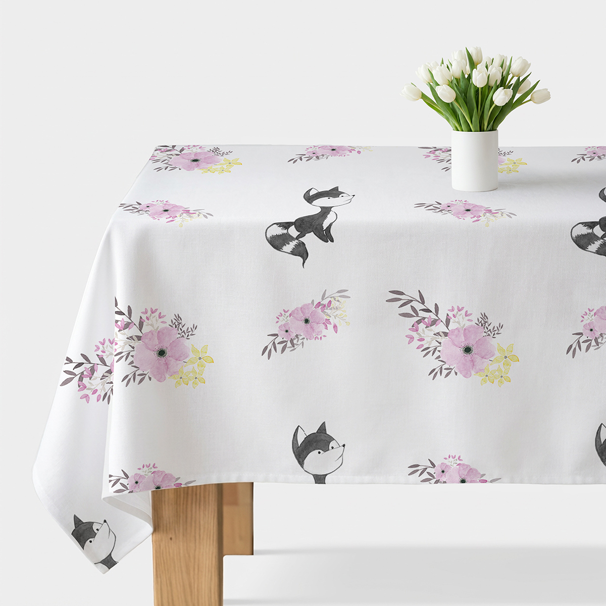 obrus rozłożony na stole z widocznymi szarymi lisami i akwarelowymi różowymi kwiatami
