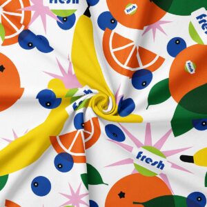 Zbliżenie na teksturę tkaniny i intensywne kolory nadruku przedstawiającego plasterki pomarańczy i jagody