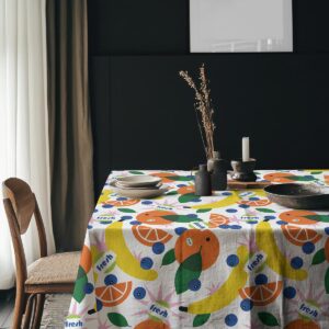 Aranżacja stołu z obrusem w owocowy wzór, naczynia i dekoracje w stylu skandynawskim