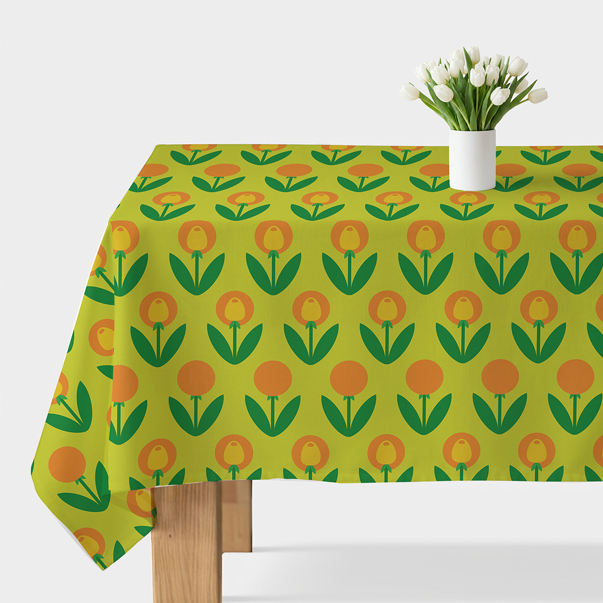 Obrus na stole z zielonym tłem i pomarańczowo-żółtymi stylizowanymi tulipanami, widok główny z białym wazonem
