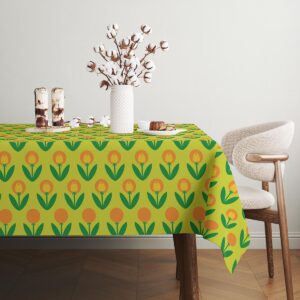 Widok rogu stołu pokazujący krawędź obrusu i regularny rytm motywu tulipanów