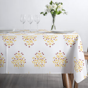 stół nakryty obrusie z gałązkami w jasnym, przytulnym wnętrzu