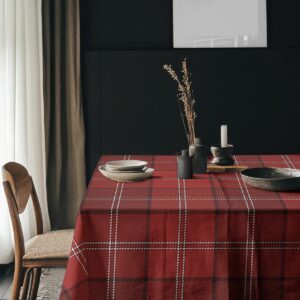 aranżacja stołu z talerzami i dekoracjami na czerwonym obrusie w kratę