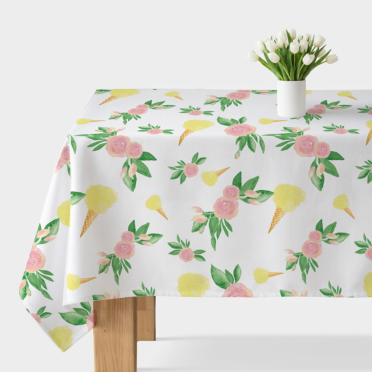 Obrus z akwarelowymi różami i żółtymi lodami na białym tle, widok na stół z wazonem tulipanów