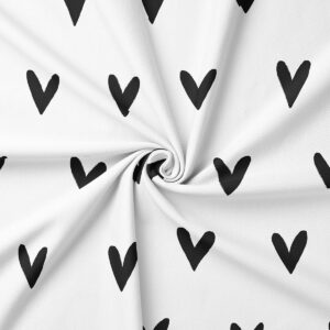 Zbliżenie na tkaninę z czarnymi serduszkami pokazujące fakturę materiału
