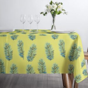 Widok na krawędź stołu z obrusowym wzorem liści palmowych i szklanymi kieliszkami