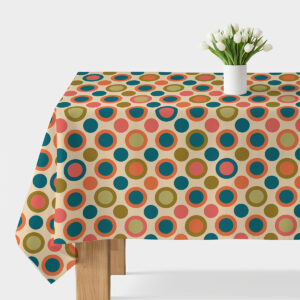 Obrus z wzorem kolorowych, okrągłych kropek na stole z białym wazonem z tulipanami