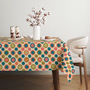 Stół nakryty obrusem z dekoracjami i naczyniami, detal kolorowego wzoru