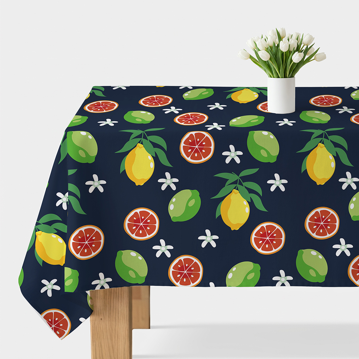 Obrus z soczystym wzorem cytrusów na granatowym tle, widok główny stołu z białym wazonem