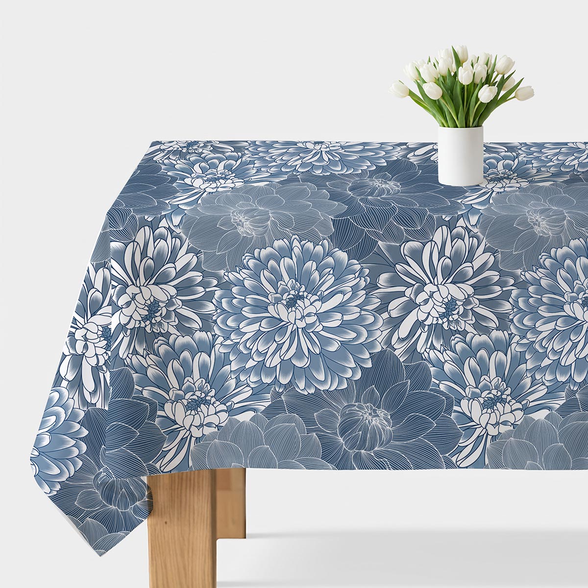 obrus z dużym nadrukiem chryzantem w odcieniach niebieskiego z białym wazonem z tulipanami