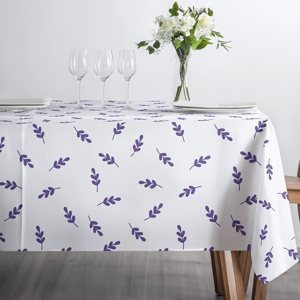 stół przygotowany do posiłku z filiżanką i dzbankiem na obrusie z fioletowymi gałązkami