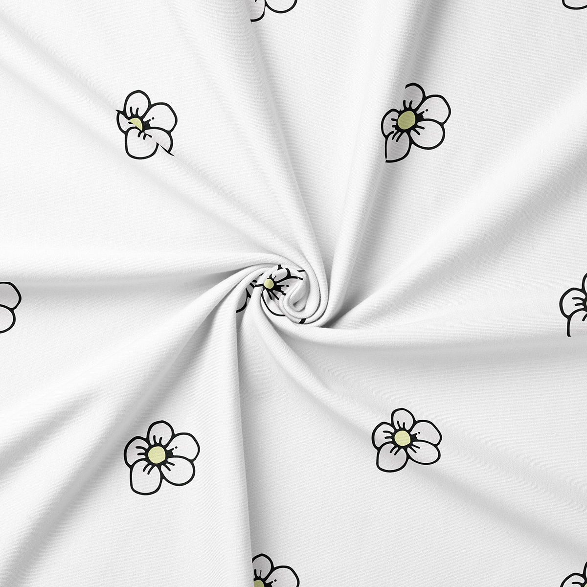 zbliżenie na tkaninę obrusową pokazujące rozmieszczenie i szczegóły małych stokrotek