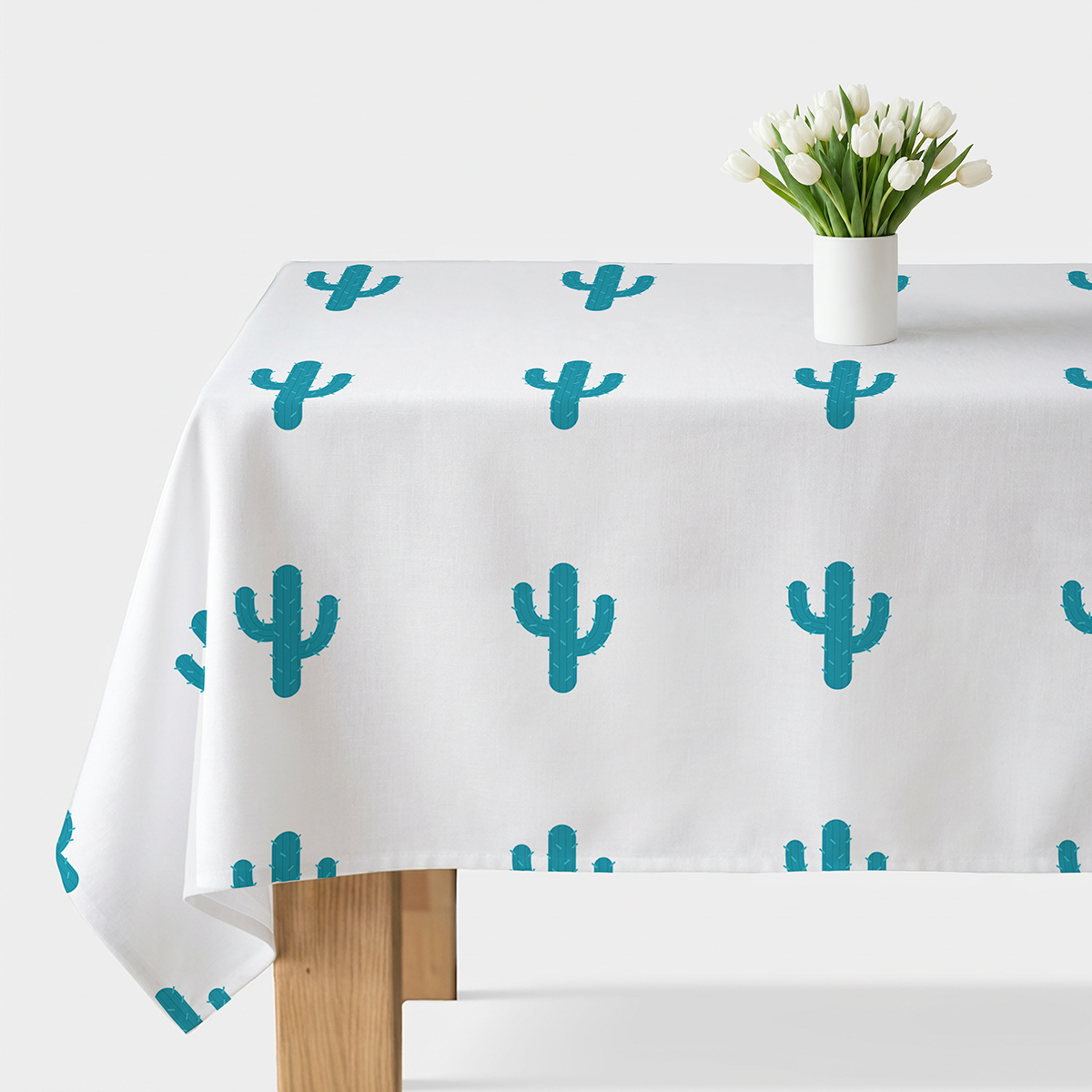 biały obrus z powtarzającym się turkusowym wzorem kaktusów na stole, ujęcie główne