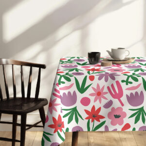 Ujęcie z małym serwisem do herbaty na obrusie z kolorowymi kwiatami