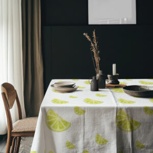 aranżacja stołu z ciemnym tłem i obrus z limonkami oraz ceramiką i suszonymi źdźbłami