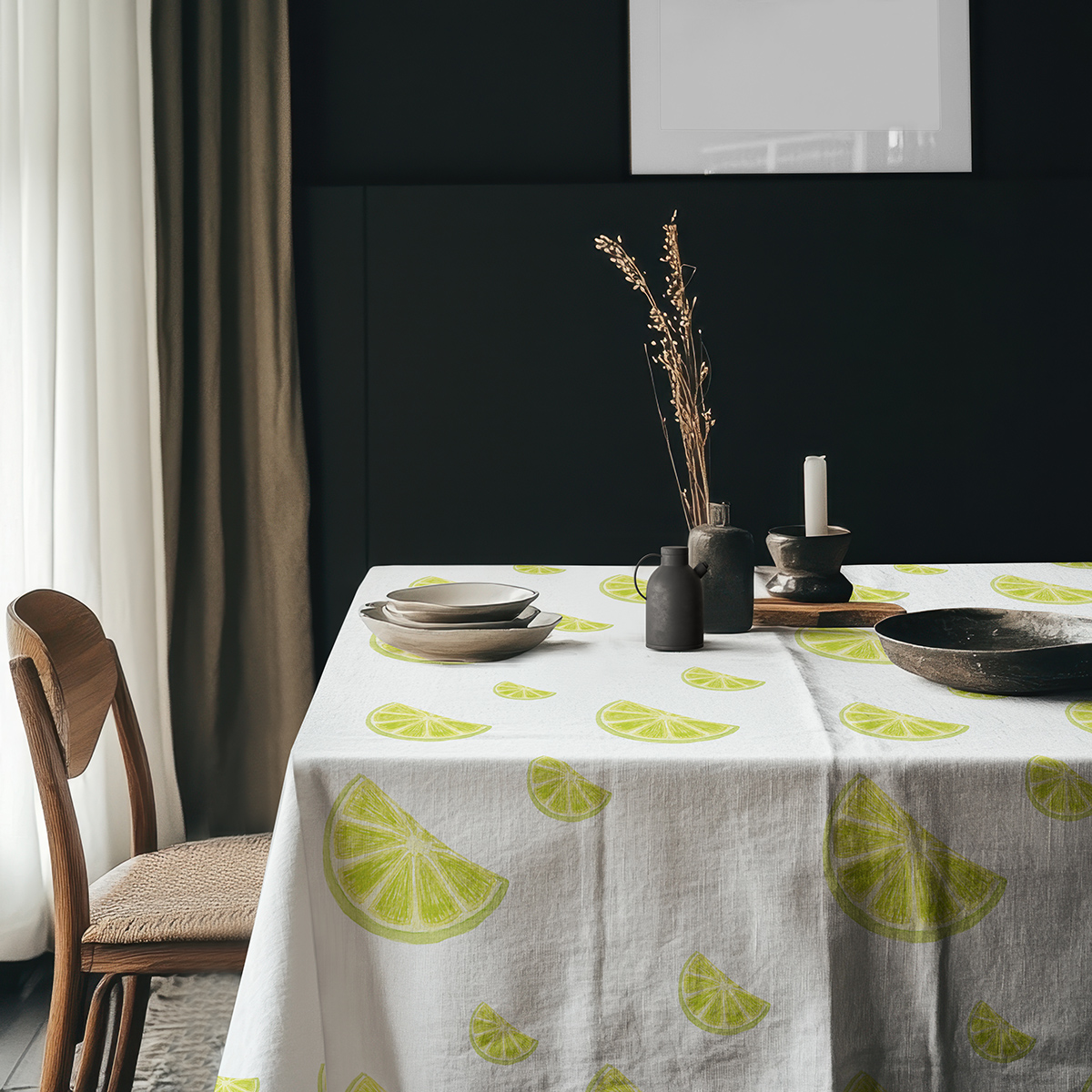aranżacja stołu z ciemnym tłem i obrus z limonkami oraz ceramiką i suszonymi źdźbłami