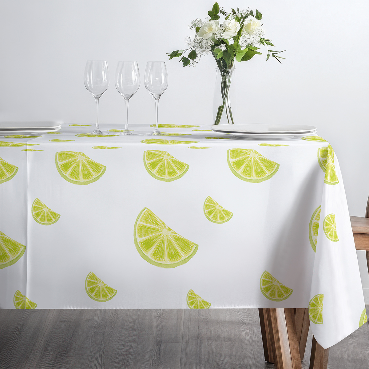 blat stołu z filiżanką i imbrykiem na jasnym obrusie ozdobionym plasterkami limonki