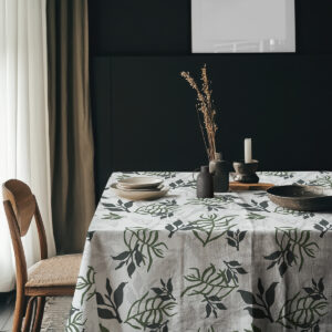 Aranżacja stołu z ceramicznymi naczyniami i dekoracjami w naturalnych kolorach na liściastym obrusie